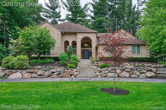 5258 Hidden Pines Dr, Brighton, MI 48116 - view of front of house featuring a front yard, brick siding, and a shingled roof