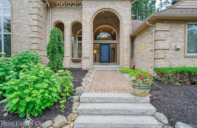 5258 Hidden Pines Dr, Brighton, MI 48116 - doorway to property with brick siding and a shingled roof