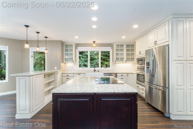 5258 Hidden Pines Dr, Brighton, MI 48116 - kitchen featuring appliances with stainless steel finishes, a center island, dark wood finished floors, decorative backsplash, and recessed lighting