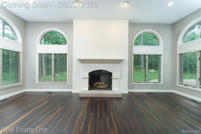 5258 Hidden Pines Dr, Brighton, MI 48116 - unfurnished living room featuring a fireplace with raised hearth, healthy amount of natural light, wood finished floors, and recessed lighting