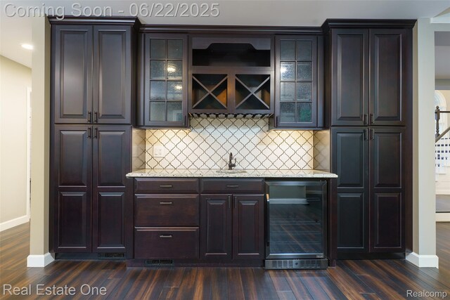 5258 Hidden Pines Dr, Brighton, MI 48116 - indoor wet bar featuring beverage cooler, dark wood finished floors, and tasteful backsplash