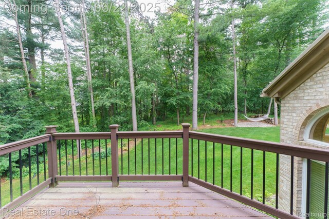 5258 Hidden Pines Dr, Brighton, MI 48116 - wooden terrace with a yard and view of wooded area