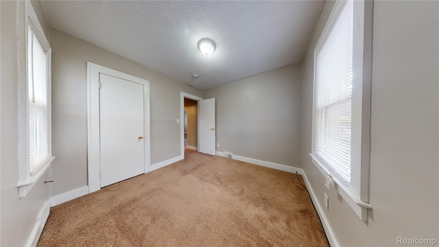 929 Kettering Ave, Pontiac, MI 48340 - unfurnished bedroom featuring carpet floors, multiple windows, a textured ceiling, and a closet