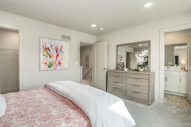 2133 Evergreen Ln Unit 28, Ann Arbor, MI 48103 - bedroom featuring light carpet, a spacious closet, recessed lighting, a closet, and ensuite bath