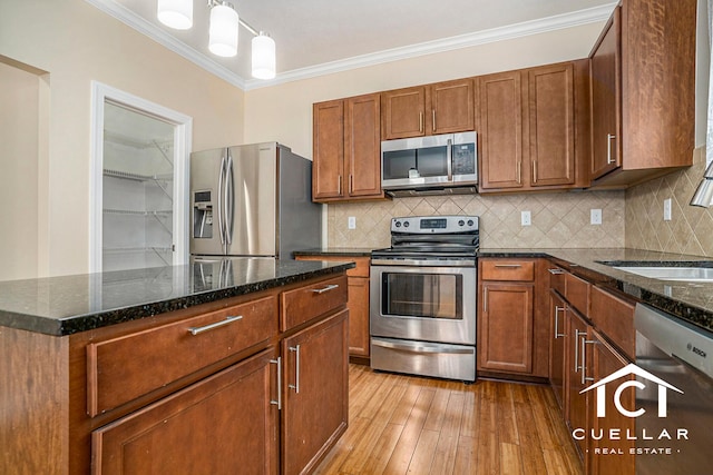 9365 Windward Dr, West Olive, MI 49460 - kitchen featuring appliances with stainless steel finishes, ornamental molding, light wood-style floors, dark stone counters, and decorative backsplash