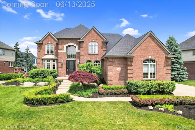 48392 Binghampton Dr, Northville, MI 48168 - traditional home with brick siding, a front yard, and roof with shingles