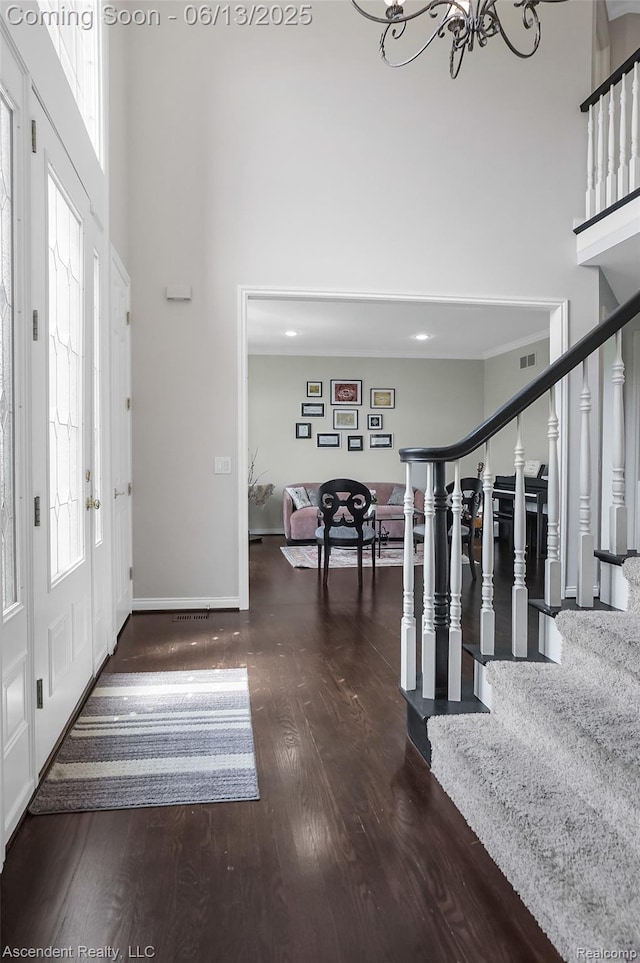 48392 Binghampton Dr, Northville, MI 48168 - foyer featuring a high ceiling, wood finished floors, a chandelier, and stairway