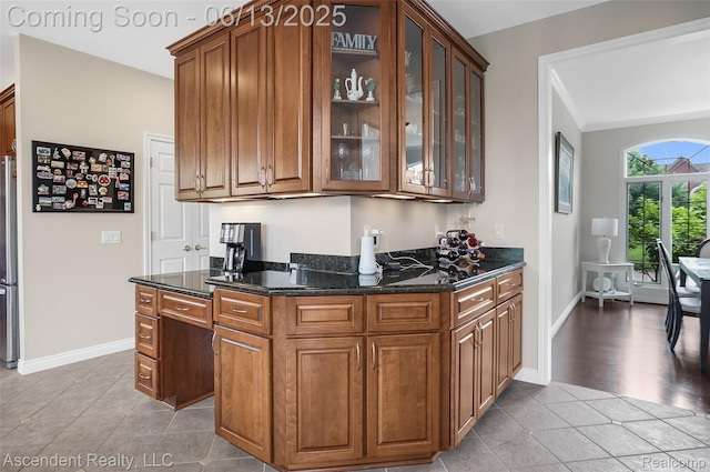 48392 Binghampton Dr, Northville, MI 48168 - kitchen featuring light tile patterned floors, glass insert cabinets, dark stone counters, and ornamental molding
