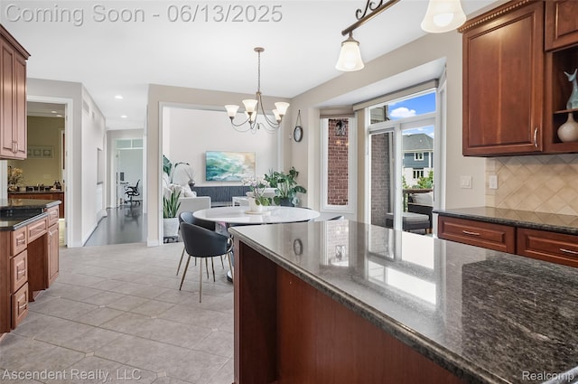 48392 Binghampton Dr, Northville, MI 48168 - kitchen with decorative backsplash, a chandelier, light tile patterned flooring, decorative light fixtures, and dark stone countertops