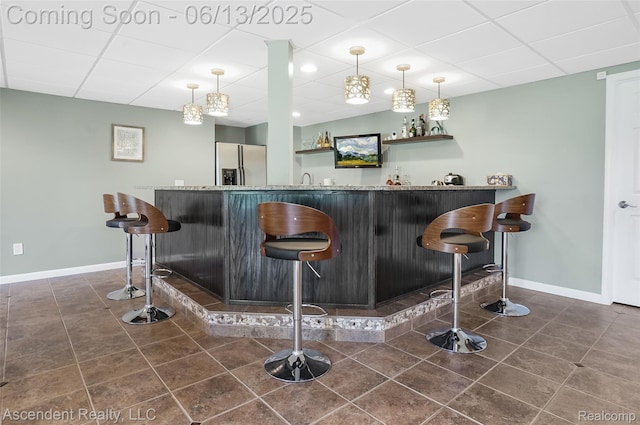 48392 Binghampton Dr, Northville, MI 48168 - indoor wet bar with stainless steel fridge with ice dispenser, dark tile patterned floors, a drop ceiling, and pendant lighting