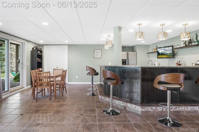 48392 Binghampton Dr, Northville, MI 48168 - indoor wet bar featuring stainless steel refrigerator with ice dispenser, recessed lighting, dark tile patterned floors, and decorative light fixtures