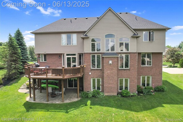 48392 Binghampton Dr, Northville, MI 48168 - rear view of property featuring a patio, a lawn, a wooden deck, brick siding, and a shingled roof