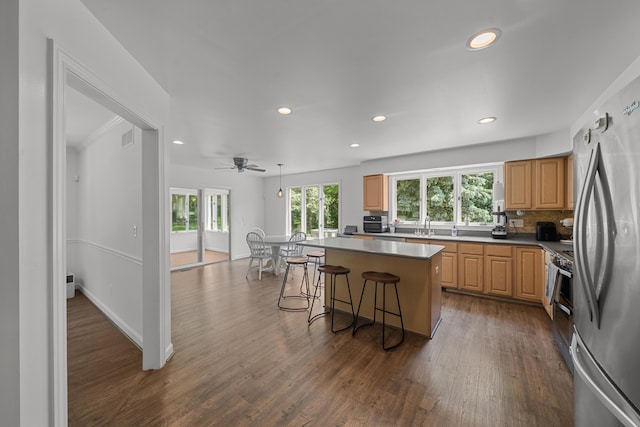 7624 Quail Ridge Dr, Dexter, MI 48130 - kitchen with appliances with stainless steel finishes, recessed lighting, a breakfast bar, a center island, and dark wood-style floors