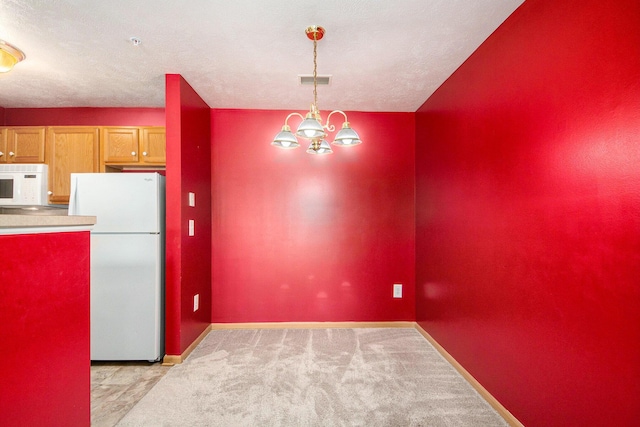 122 Ida Red Ave NW Unit 202, Sparta, MI 49345 - kitchen featuring white appliances, a chandelier, light carpet, and pendant lighting