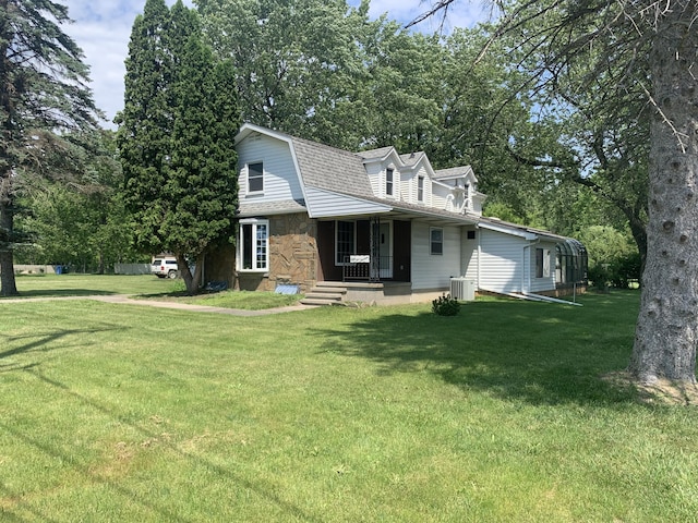 5513 S Waverly Rd, Lansing, MI 48911 - view of front facade with a gambrel roof, stone siding, a front lawn, and roof with shingles