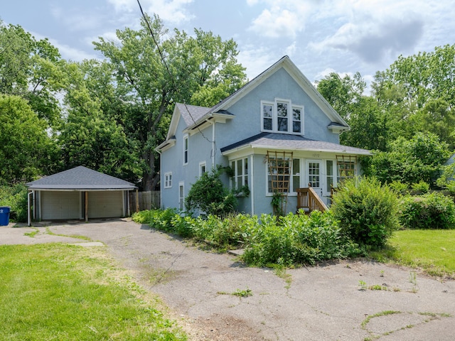 1232 Upland Dr, Kalamazoo, MI 49048 - view of front of house with a detached garage, an outbuilding, stucco siding, and a front lawn