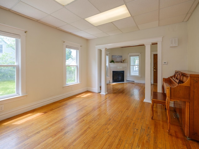 1232 Upland Dr, Kalamazoo, MI 49048 - living room featuring light wood-type flooring, decorative columns, a drop ceiling, and healthy amount of natural light