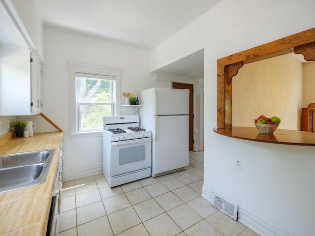 1232 Upland Dr, Kalamazoo, MI 49048 - kitchen with white appliances, white cabinets, light tile patterned floors, and light countertops