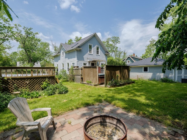 1232 Upland Dr, Kalamazoo, MI 49048 - back of property featuring an outdoor fire pit, a deck, a lawn, and a patio