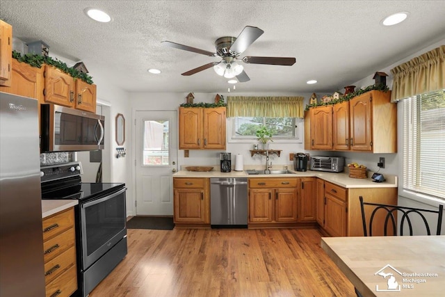 4162 9th St, Newport, MI 48166 - kitchen featuring stainless steel appliances, light countertops, a ceiling fan, a textured ceiling, and light wood-style floors