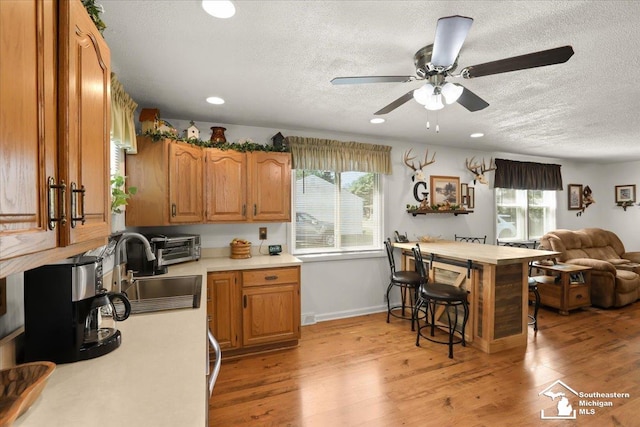 4162 9th St, Newport, MI 48166 - kitchen featuring a textured ceiling, light countertops, plenty of natural light, brown cabinetry, and recessed lighting