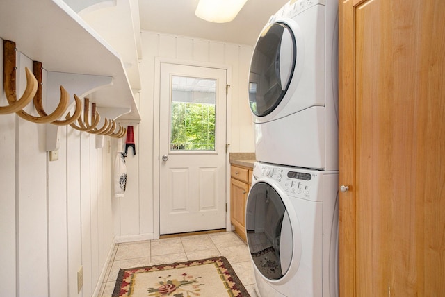 2347 W W Dowling Rd, Delton, MI 49046 - laundry area with stacked washer and clothes dryer, light tile patterned floors, and cabinet space