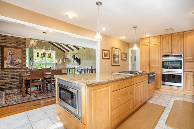 2347 W W Dowling Rd, Delton, MI 49046 - kitchen featuring appliances with stainless steel finishes, light tile patterned floors, a chandelier, a center island, and a warming drawer