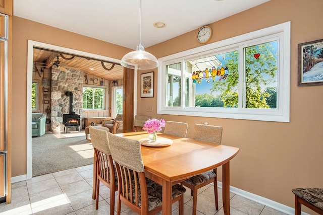 2347 W W Dowling Rd, Delton, MI 49046 - dining room featuring a wood stove, vaulted ceiling, wooden ceiling, and light tile patterned floors