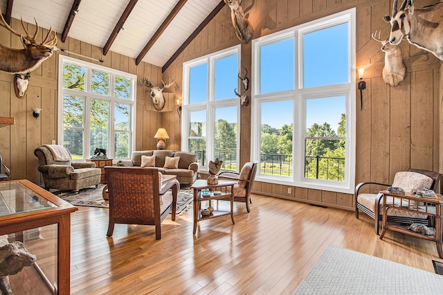 2347 W W Dowling Rd, Delton, MI 49046 - living room featuring wooden walls, high vaulted ceiling, light wood-style floors, and a wood ceiling with exposed beams
