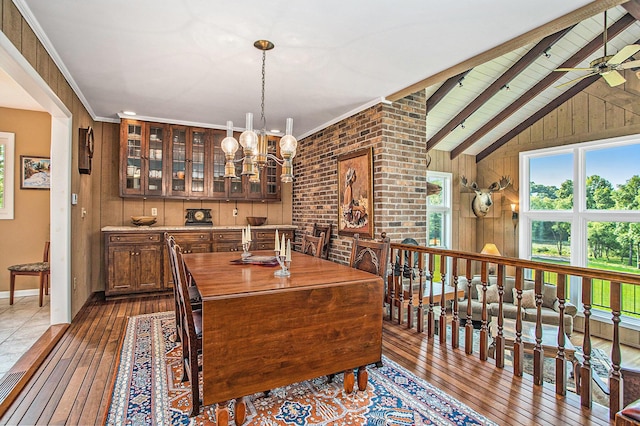 2347 W W Dowling Rd, Delton, MI 49046 - dining area with dark wood-style flooring, wooden walls, a chandelier, and a ceiling fan