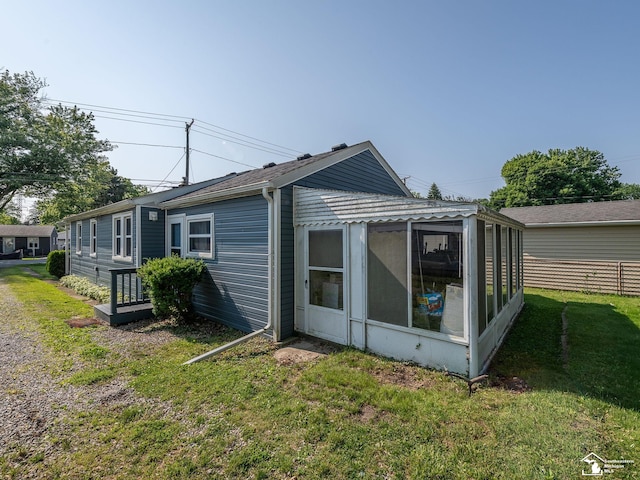 2109 Spaulding Rd, Monroe, MI 48162 - view of side of home with a sunroom and a yard
