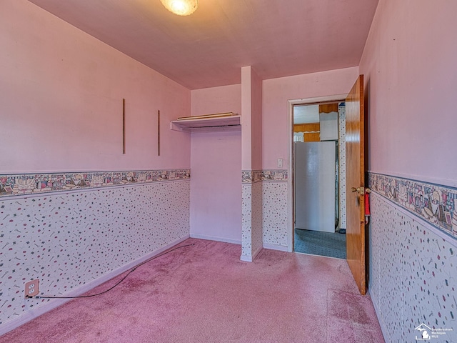 2109 Spaulding Rd, Monroe, MI 48162 - unfurnished bedroom featuring a wainscoted wall, freestanding refrigerator, carpet, a closet, and wallpapered walls