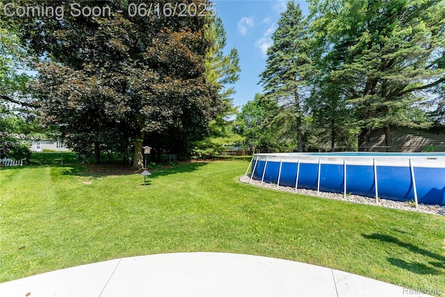 11704 Schram St, Grand Blanc, MI 48439 - view of green lawn with an outdoor pool and view of scattered trees