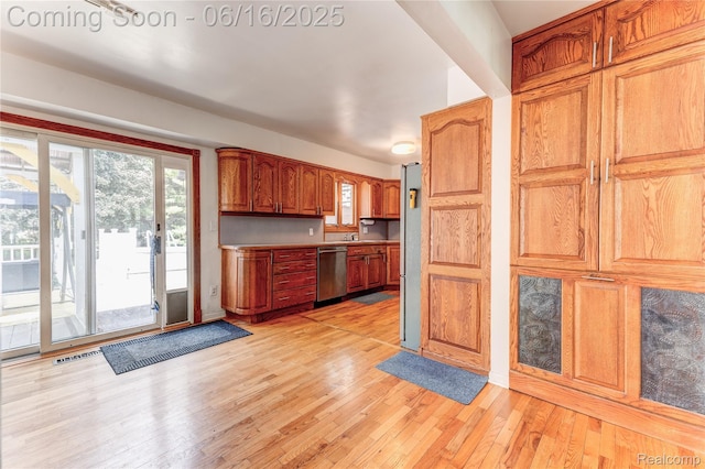 11704 Schram St, Grand Blanc, MI 48439 - kitchen with stainless steel dishwasher, light wood-style floors, brown cabinets, and light countertops