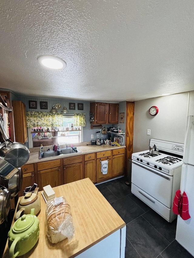 21794 30th Ave, Barryton, MI 49305 - kitchen featuring white appliances, a textured ceiling, brown cabinets, and dark tile patterned floors