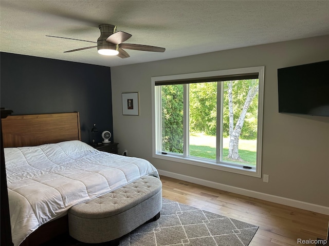 6771 Foxboro, Brighton, MI 48116 - bedroom featuring hardwood / wood-style floors, a textured ceiling, and a ceiling fan