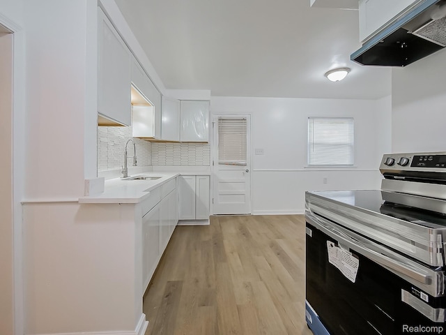 23740 Lee Baker Dr, Southfield, MI 48075 - kitchen with stainless steel electric range oven, exhaust hood, white cabinetry, and light wood-style flooring