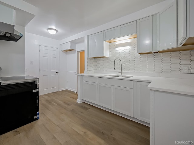23740 Lee Baker Dr, Southfield, MI 48075 - kitchen featuring decorative backsplash, wall chimney exhaust hood, light wood-type flooring, and light countertops