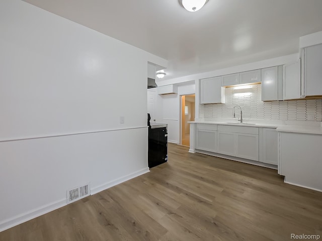 23740 Lee Baker Dr, Southfield, MI 48075 - kitchen with light wood-style floors, tasteful backsplash, range, and light countertops