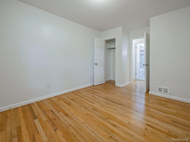 23740 Lee Baker Dr, Southfield, MI 48075 - unfurnished bedroom featuring light wood-type flooring, an AC wall unit, and a closet
