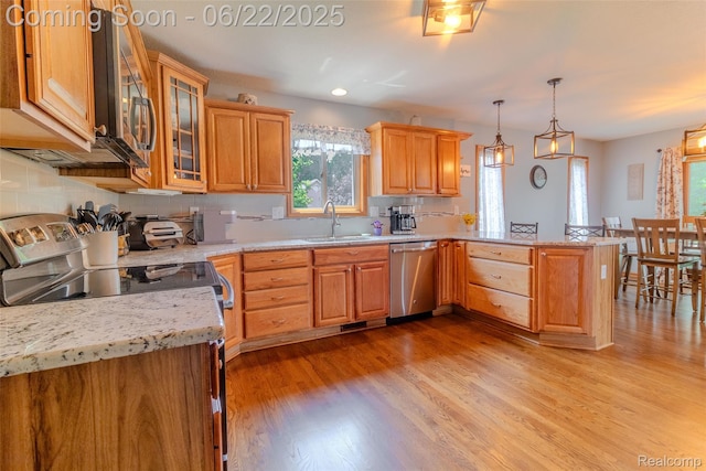 15980 Monterey St, Southgate, MI 48195 - kitchen featuring appliances with stainless steel finishes, a peninsula, light wood-style flooring, backsplash, and glass insert cabinets