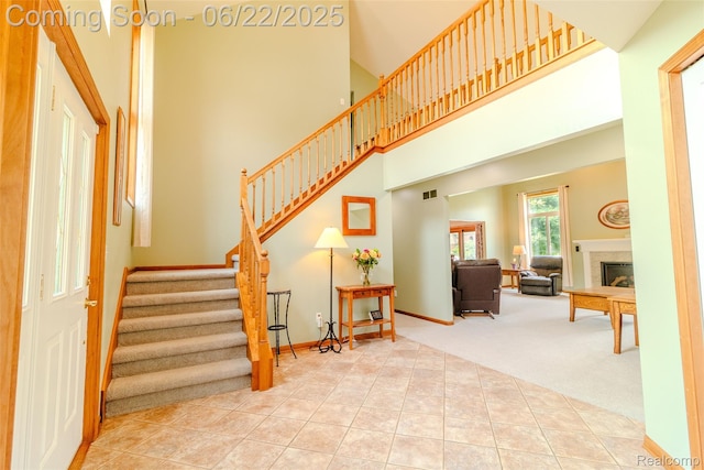 15980 Monterey St, Southgate, MI 48195 - stairs featuring carpet, a towering ceiling, tile patterned flooring, and a fireplace