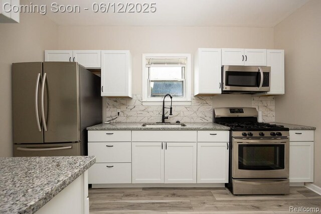15834 Baylis St, Detroit, MI 48238 - kitchen featuring appliances with stainless steel finishes, white cabinets, tasteful backsplash, and light stone counters