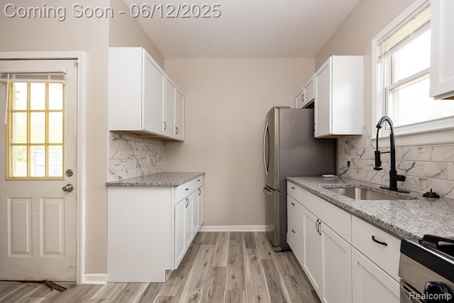 15834 Baylis St, Detroit, MI 48238 - kitchen featuring stove, white cabinets, light wood-style floors, and backsplash