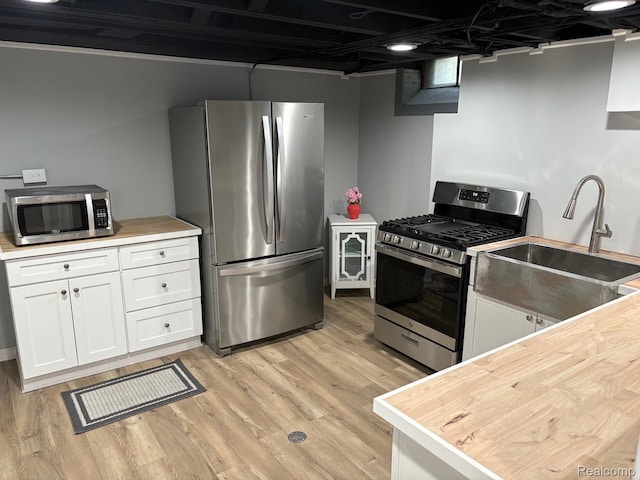 2211 Parkside St, Trenton, MI 48183 - kitchen featuring appliances with stainless steel finishes, white cabinetry, and light wood finished floors
