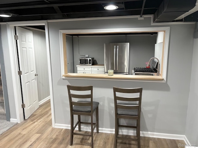2211 Parkside St, Trenton, MI 48183 - kitchen featuring stainless steel appliances, wood finished floors, and a breakfast bar