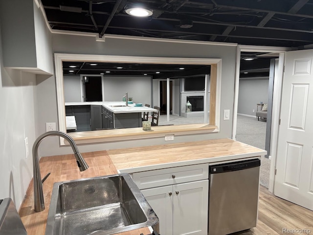 2211 Parkside St, Trenton, MI 48183 - kitchen featuring dishwasher, wood counters, light wood-style floors, and white cabinetry