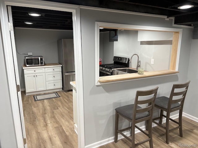 2211 Parkside St, Trenton, MI 48183 - kitchen featuring stainless steel appliances, light wood-type flooring, and white cabinets