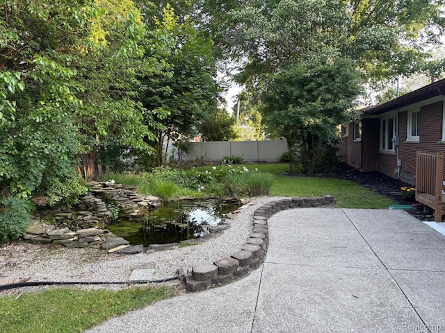 2211 Parkside St, Trenton, MI 48183 - fenced backyard with a patio area and a garden pond