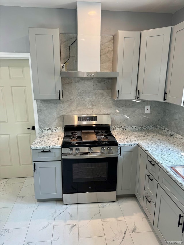 1112 Brockway Rd, Saginaw, MI 48602 - kitchen featuring stainless steel gas stove, wall chimney exhaust hood, light marble finish flooring, and gray cabinets